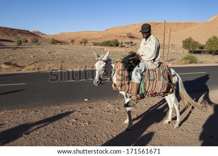 ATLAS MOUNTAIN, MOROCCO - OCTOBER 9: Unidentified man riding donkey near Essaouria on October 9, 2013 in Morocco. Only portion of population lives countryside.