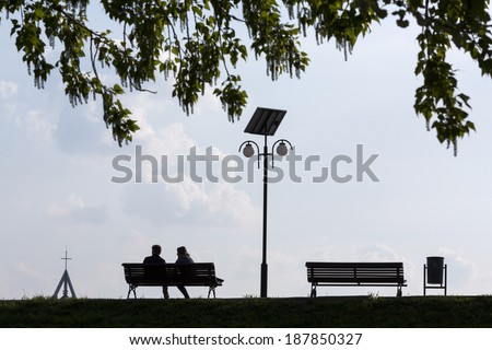 Happy couple in love on bench unde a tree in the night