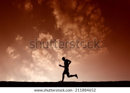 Silhouette of sport man running with blue sky and clouds on background