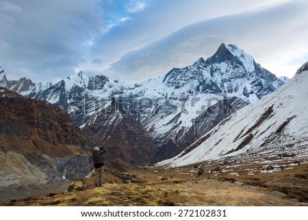 Man taking photos of Machhapuchchhre (Fish Tale) from Annapurna Base Camp Himalaya Mountains in Nepal