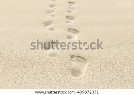 human footprints on the beach sand.