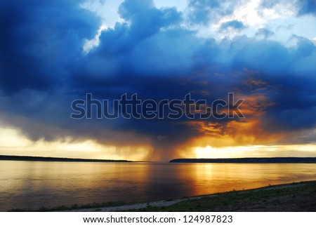 colorful sunset over the river, the sky is dark blue with orange clouds