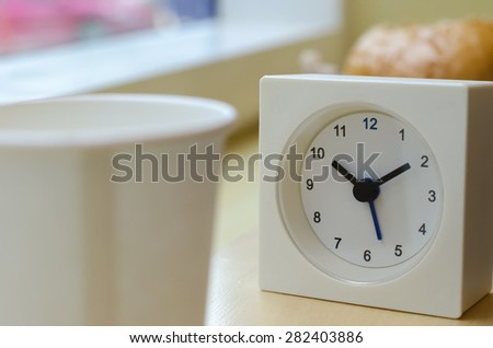 The clock displays the time ten o\'clock ten minutes on mini bar side of the window  At coffee shop in  Bangkok