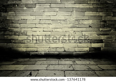 Empty old spacious room with stone grungy wall weathered dirty floor, vintage background texture of brickwall