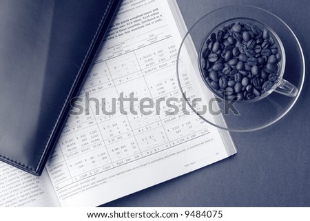 Toned business still life with financial report, cardholder and cup of coffee beans