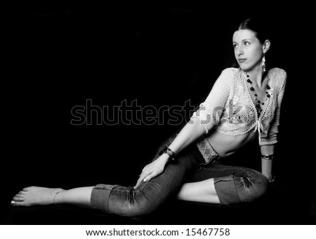 Young sensual sitting woman in jeans and blouse with opened belly