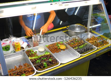 Glass case with roasted scorpions and water bugs as snack food in Thailand