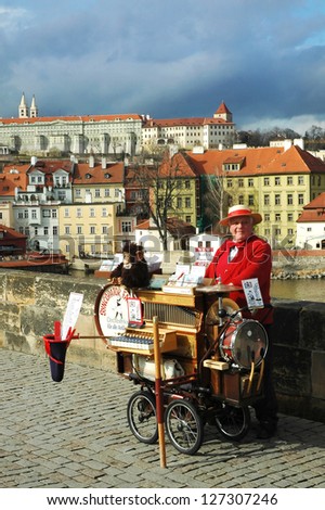 PRAGUE - MARCH 3. Local attraction - a man offers music from hand operated music box in exchange for money.   on Charles Bridge in Prague, Czech Republic, on March 3 2007.