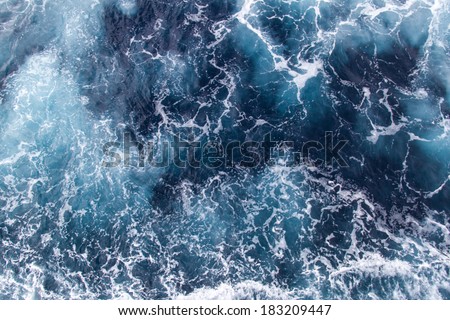 Background blue waves of the sea with sea foam