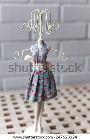 Miniature mannequin in a summer dress on a white background
