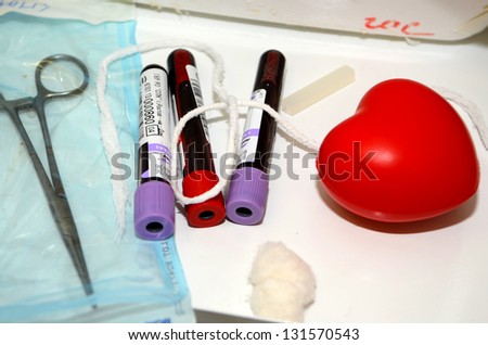 ROSTOV-ON-DON, RUSSIA - MARCH 2: Medical clamp, tubes with donor blood, rubber red heart-The City Blood Service makes promo action for donorship popularization, March 2, 2013 in Rostov-on-Don, Russia