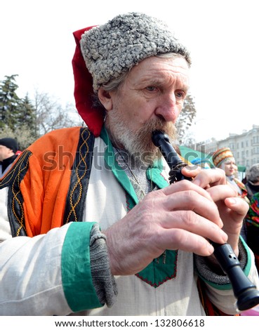 ROSTOV-ON-DON, RUSSIA - MARCH 17: Cossack plays on a makeshift instrument.The Cossack Maslenitsa - traditional celebration and national ski races around, March 17, 2013 in Rostov-on-Don, Russia