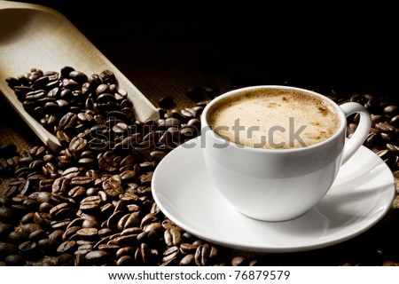 A cup of cappuccino with coffee bean as background