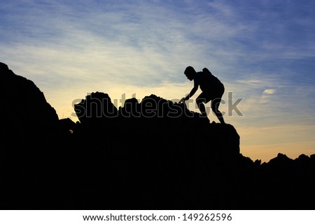 Silhouette Climbing a mountain