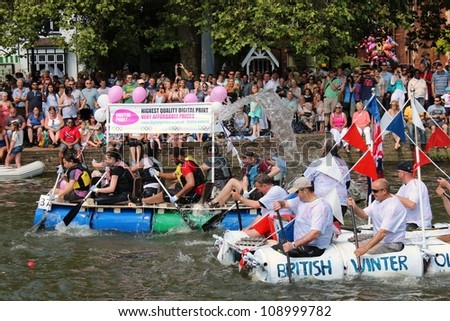 BEDFORD, ENGLAND - JULY 22: People race self built rafts down the River Great Ouse at the bi-annual Bedford River Festival on 22 July 2012 in England.