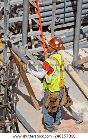 NEW YORK CITY, NEW YORK - APRIL 28, 2014: Construction worker at construction site near the High Line. Its popularity has led to dozens of new residential and commercial buildings along its route.