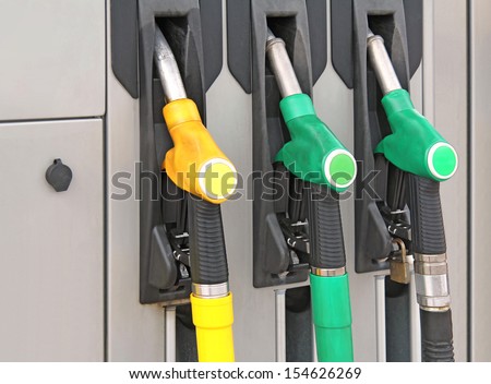 Yellow and green Pump nozzles at the gas station