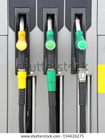 Yellow and green Pump nozzles at the gas station
