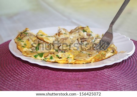Scrambled eggs with mushrooms boletus on the plate