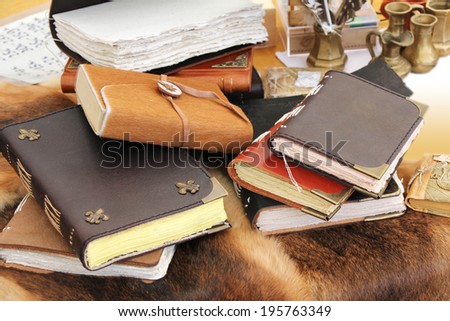 Old books and inkstand on the fur leather