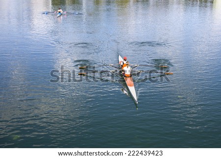 Two Women Rower in a boat, rowing on the tranquil lake