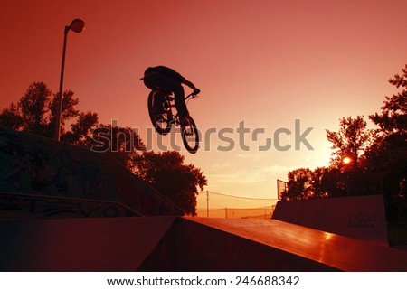 Silhouette of a Young cyclists to jump on the ramp