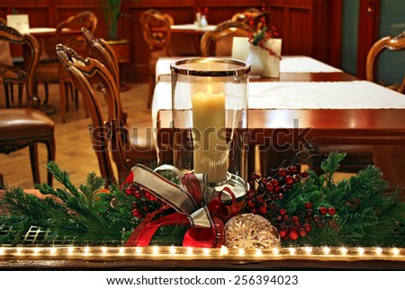 Christmas decoration with burning candle in the window room with old furniture