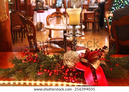 Christmas decoration with burning candle in the window room with old furniture