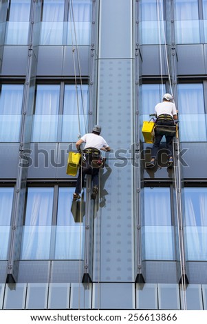 Two climbers wash windows and glass facade of the skyscraper