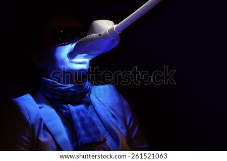 Male patient in a dental treatment, getting teeth whitened