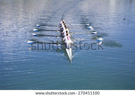 Boat coxed eight Rowers rowing on the blue lake