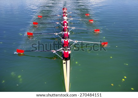 Boat coxed eight Rowers rowing on the blue lake