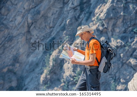 tourist with map in mountain