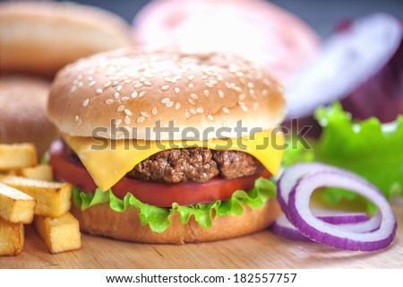 appetizing cheeseburger with red onion closeup