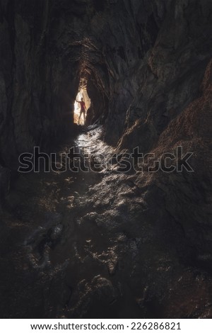 Girl silhouette on dark cave. Carpathians, Ukraine, Europe