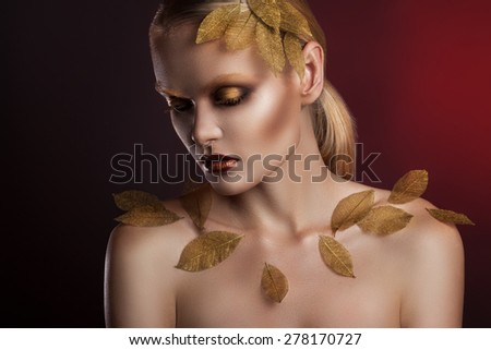 beautiful elegant woman in accessories with gold leaves.  portrait