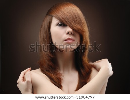 Portrait of young beautiful woman folding arms round her shoulders