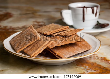 Plate full of cookies and coffe cup with chocolate flowing