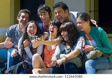 Students Laughing While Looking At Cell Phone
