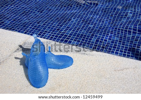 Children blue rubber shoes near a swimming pool