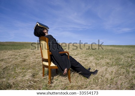 Business man with a book on his head having a rest on the nature