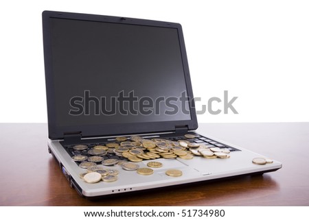 Laptop on a desk with many euro coins