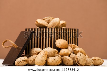 Almonds in a wooden box on a brown background