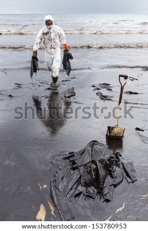 Rayong, Thailand - July 31, 2013: A Worker In Biohazard Suit During The Clean-Up Operation From Crude Oil Spilled Into Ao Prao Beach On July 31, 2013 In Rayong Province, Thailand.