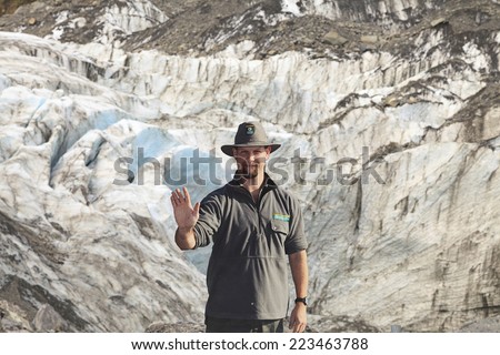 WEST COAST, NEW ZEALAND -MAY 20: Park Ranger in stop action as warning sign at Fox Glacier on May 20, 2013 in West Coast, NZ. Many tourists have died or been seriously injured after ignoring this sign