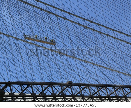 NEW YORK - APRIL 30: Construction workers crew repair cables on the  Brooklyn Bridge on April 30, 2013. The Brooklyn Bridge is the one of the oldest suspension bridges in the USA was completed in 1883