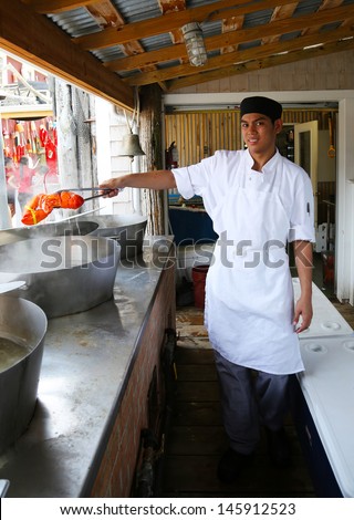 BAR HARBOR, MAINE - JULY 6: Cook holding boiled lobster in Stewman s restaurant in Maine on July 6, 2013.   Bar Harbor is a famous location in Down East Maine with a long history of lobstering