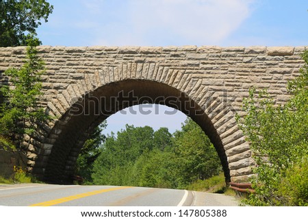 ACADIA NATIONAL PARK, MAINE - JULY 7: Stone Arch Bridge in Acadia National Park on July 7, 2013. 45 miles of rustic carriage roads in Acadia Park have 17 unique in design stone-faced bridges