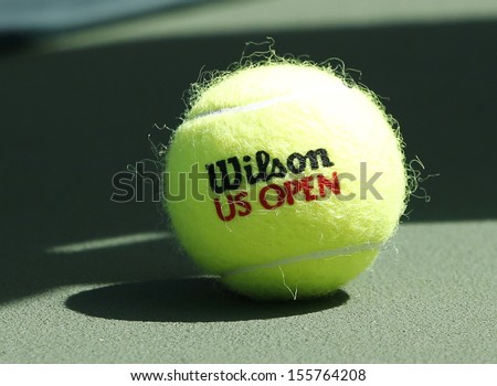 FLUSHING, NY - SEPTEMBER 5: Wilson tennis ball on tennis court at Arthur Ashe Stadium on September 5, 2013 in Flushing, NY. Wilson is the Official Ball of the US Open since 1979