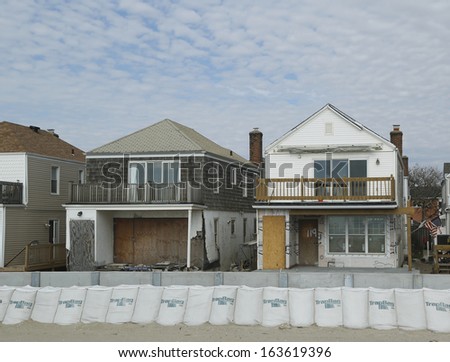 FAR ROCKAWAY, NY - OCTOBER 22: Damaged beach houses in devastated area one year after Hurricane Sandy on October 22, 2013 in Far Rockaway, NY. Notice protective barrier build to prevent flooding